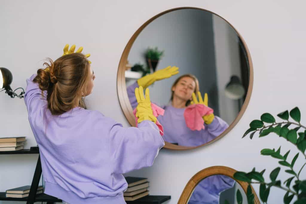 Lady enjoying a freshly cleaned mirror by admiring herself in it